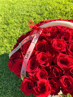 Close-up of red roses and LaFia ribbon on the basket outdoors