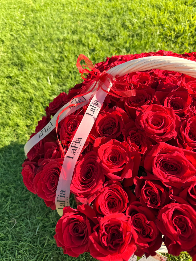 Close-up of red roses and LaFia ribbon on the basket outdoors